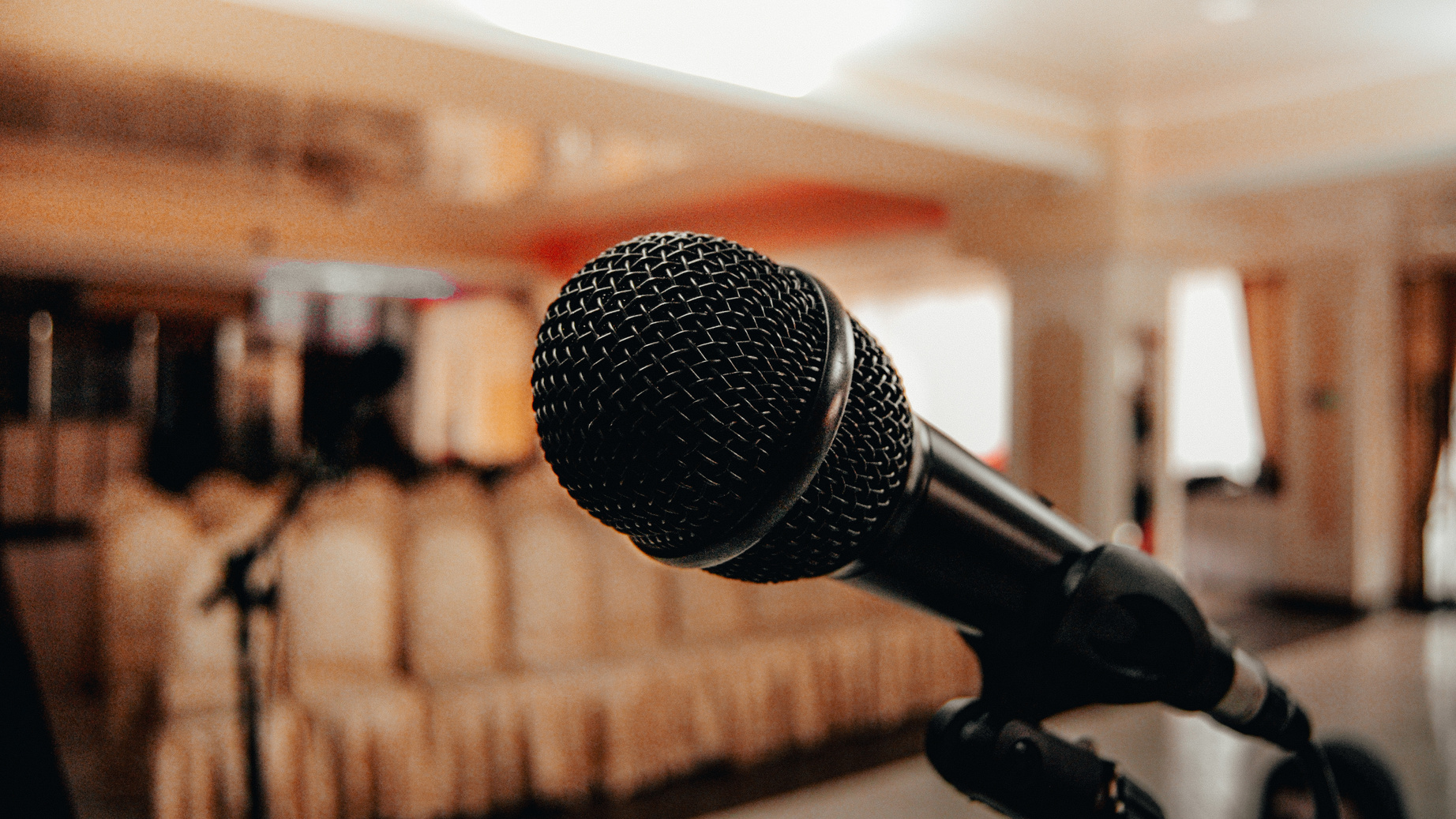 Black microphone in light conference hall